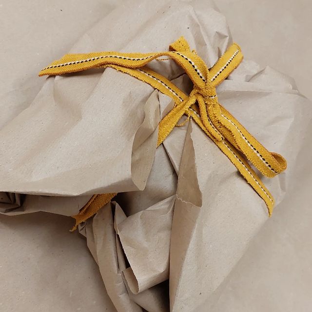Paquet cadeau réalisé en papier d'emballage et bande de chute de tissu